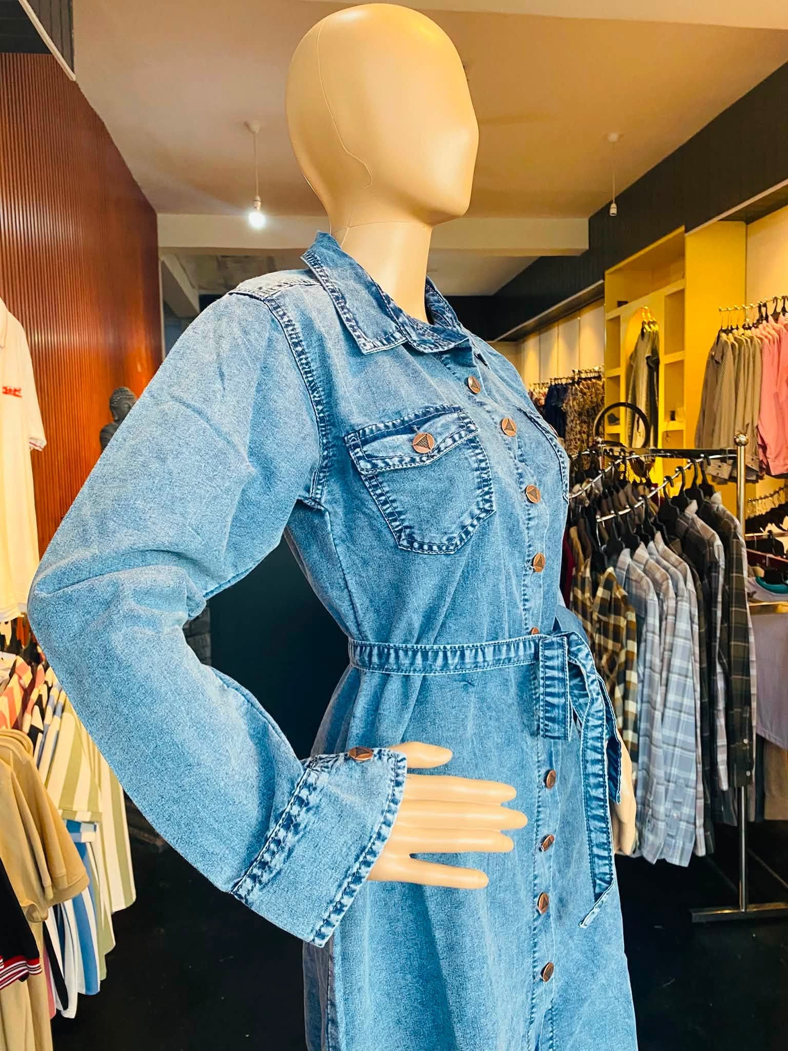 Close-up of the neckline and gathered tie waist on a blue denim frock